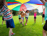 Elementary Students under rainbow parachute